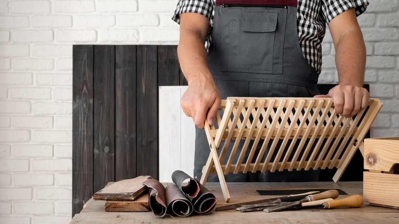 Person arbeitet an einem Holzobjekt mit Platz für Text.