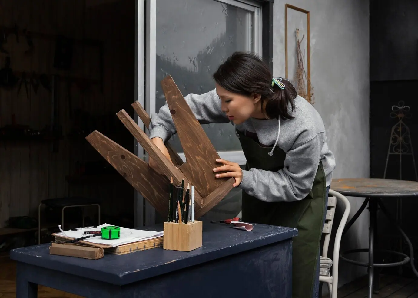 Mittlere Einstellung einer Frau, die einen Stuhl hält.